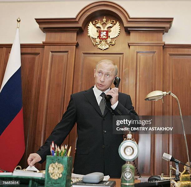 Russian President Vladimir Putin speaks on the phone in his office in Moscow's Kremlin, 12 September 2007. Putin accepted Wednesday the resignation...