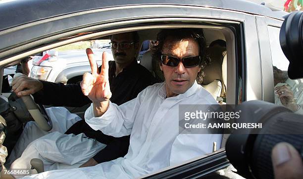 Pakistani opposition leader Imran Khan sits in a car as he makes a victory sign during a protest rally in Islamabad, 12 September 2007. Pakistani...