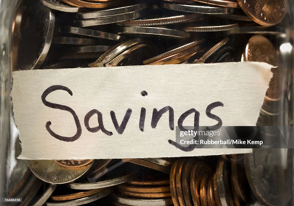 Detailed view of glass jar with change and savings label