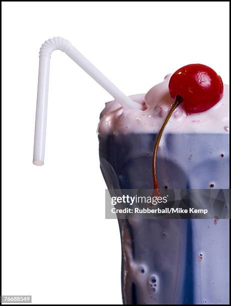 close-up of melting milkshake with straw and maraschino cherry - maraschino stock pictures, royalty-free photos & images