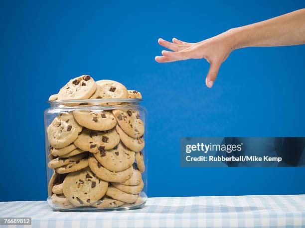 hand reaching for chocolate chip cookie jar - child cookie jar stock pictures, royalty-free photos & images