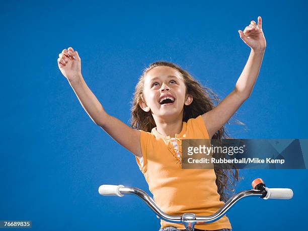 girl riding bicycle with no hands smiling - freihändiges fahrradfahren stock-fotos und bilder