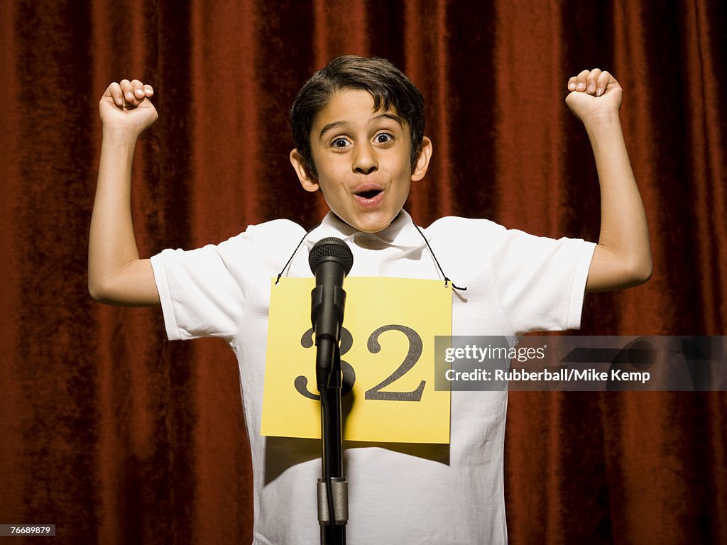 Boy contestant standing at microphone cheering