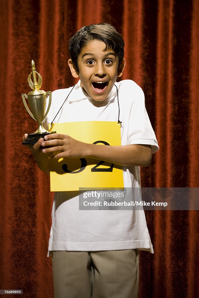 Boy contestant holding trophy