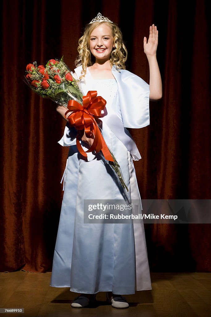 Beauty pageant winner smiling and holding roses