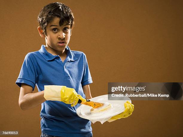 boy with rubber gloves scrubbing plate - kids with cleaning rubber gloves stock-fotos und bilder