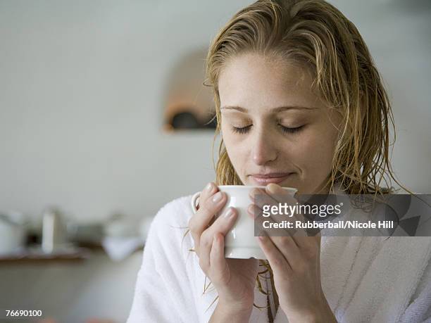woman in bathrobe holding mug with eyes closed - woman smiling eyes closed stock pictures, royalty-free photos & images