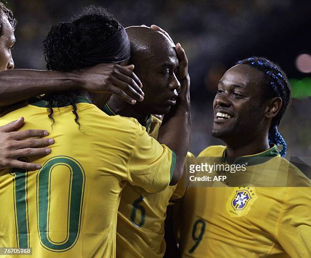 Brazil's Kleber celebrates with teammates Ronaldinho and Vagner Love after scoring a goal in the first half against Mexico in a friendly match of the...