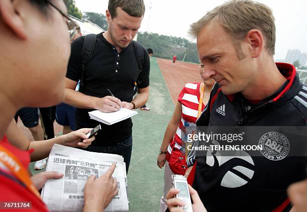 Reporter shows a local newspaper report for an incident that occured 12 August to Denmark's Coach Kenneth Heiner-Moller during a press conference...