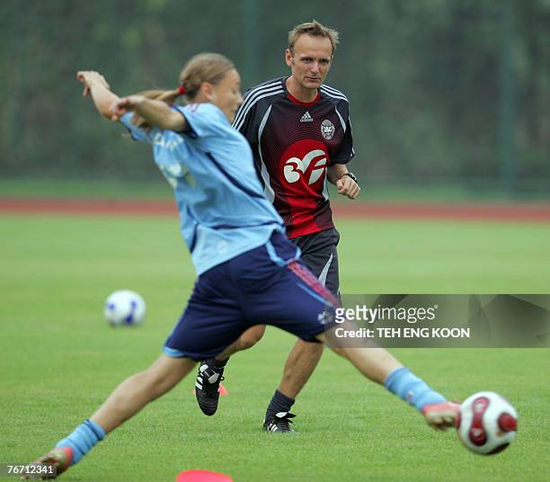 Denmark's Coach Kenneth Heiner-Moller trains with his players during a training session for the Women's World Cup 2007 football match, in Wuhan, in...