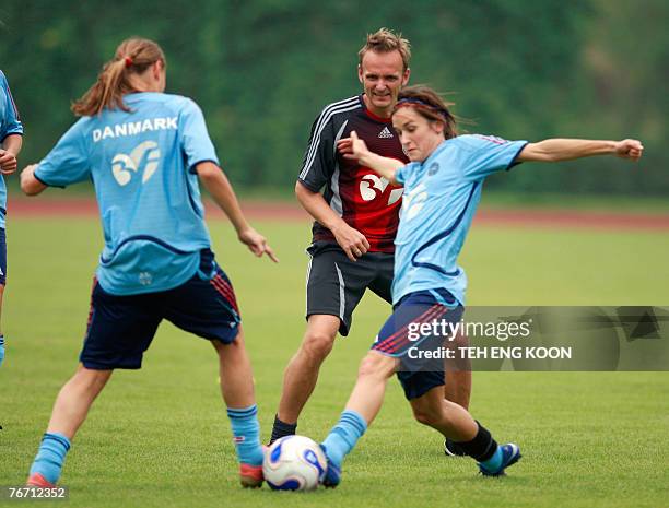 Denmark's Coach Kenneth Heiner-Moller trains with his players during a training session for the Women's World Cup 2007 football match, in Wuhan, in...