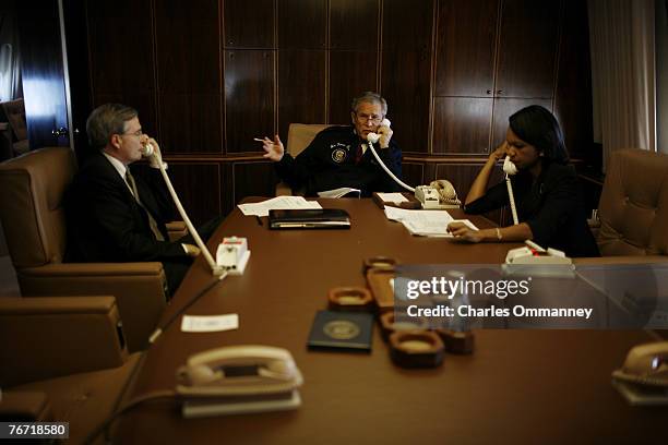 President Bush flanked by Secretary Rice and National security advisor Steve Hadley place a secure call on AF1 through to Jordan?s King Abdullah to...