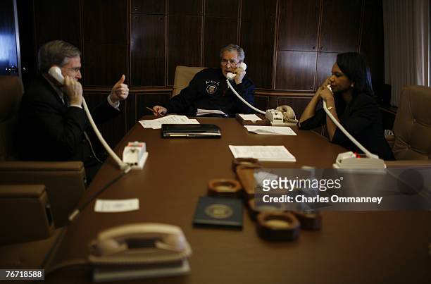 President Bush flanked by Secretary Rice and National security advisor Steve Hadley place a secure call on AF1 through to Jordan?s King Abdullah to...
