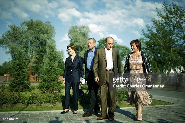 Russian President Vladimir Putin and US President George W. Bush wave as they pose with their wives Laura Bush and Lyudmila Putina during their...