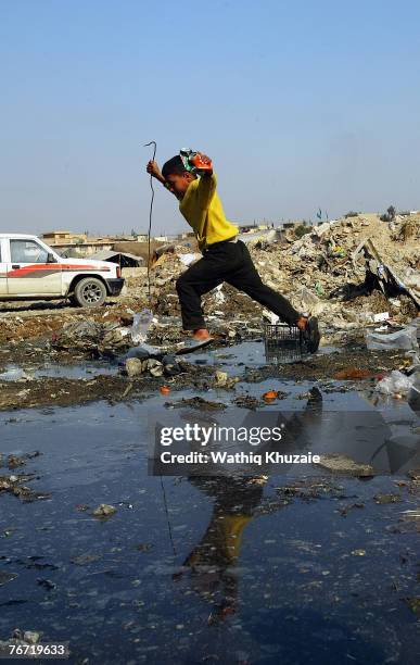 An Iraqi boy walks near sewage water on February 14, 2007 in the street of Baghdad, Iraq.