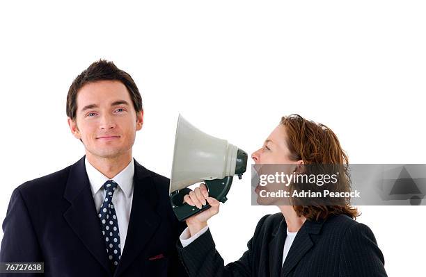 woman yelling through megaphone at man - exigir fotografías e imágenes de stock