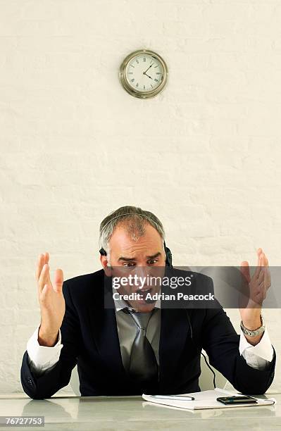 businessman with telephone headset - unhappy salesman stock pictures, royalty-free photos & images