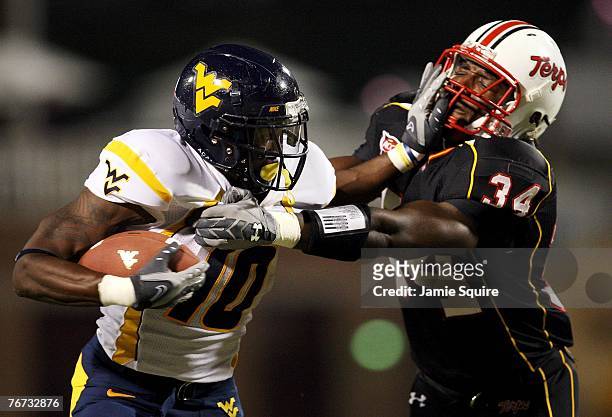 Running back Steve Slaton of the West Virginia Mountaineers carries the ball as he stiff-arms Dave Philistin of the Maryland Terrapins during the...