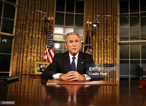 President George W. Bush poses for photographers after addressing the nation on the military and political situation in Iraq from the White House...