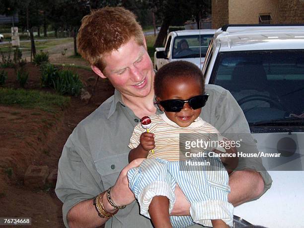 Undated Clarence House handout photo of Prince Harry with a child from one of the projects being helped by the Lesotho Fund. Prince Harry has thanked...