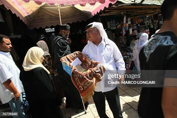 Palestinian man carries a donation box 14 September 2007 while worshipers rush to reach the Al-Aqsa compound to perform the first ritual Friday...