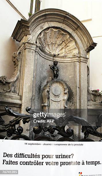 This illustration picture shows a banner in front of the famous Belgian statue Manneke Pis who seems to have problems peeing 14 September 2007,...