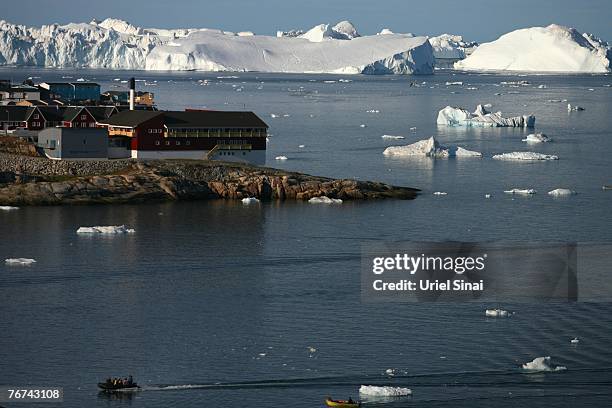 Fishermen boat sail to the harbor August 25 near the town of IlulissatGreenland. Even though the disappearing ice cap could lead to higher sea levels...