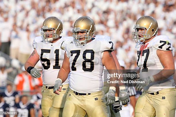 Offensive gaurd Dan Wenger, offensive lineman John Sullivan and left gaurd Mike Turkovich of the University of Notre Dame Fighting Irish walk to the...