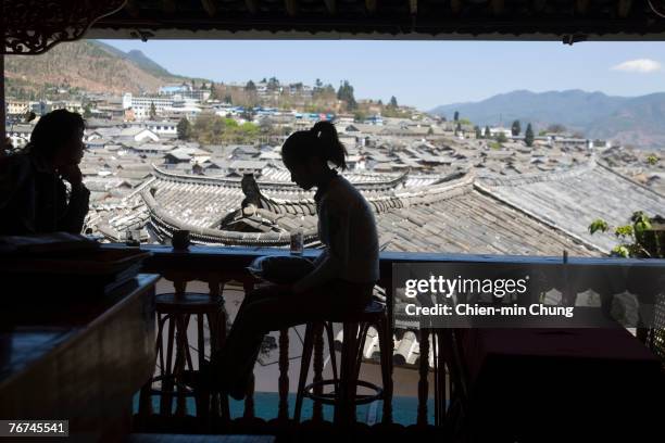 Chinese tourists enjoy a quiet moment in a bar on March 19, 2006 in Lijiang, China. Nested deep in the cascading Himalaya Mountains, old Lijiang's...