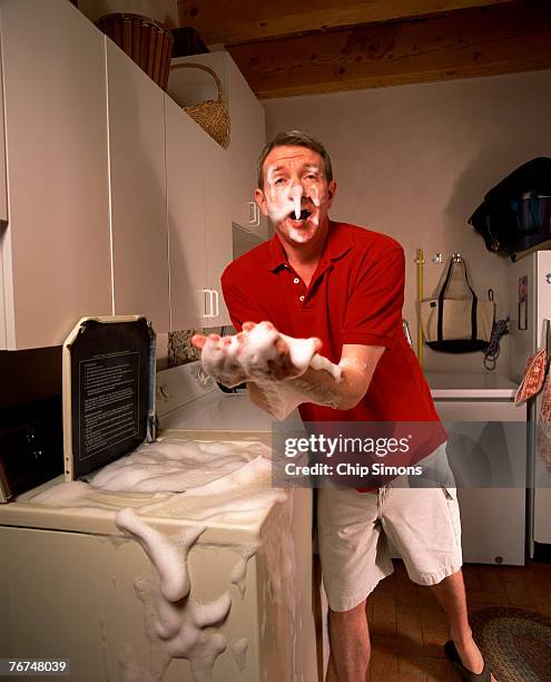 man with overflowing washing machine - washing machine with bubbles stock pictures, royalty-free photos & images