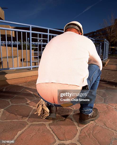 construction worker squatting - fesses photos et images de collection