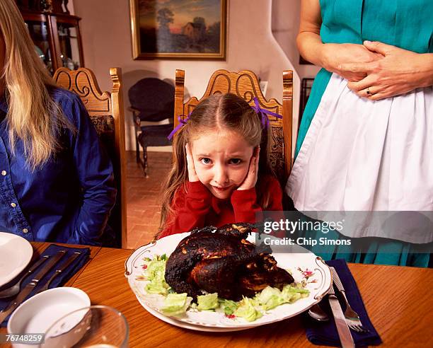 girl with burnt chicken - awkward dinner stock pictures, royalty-free photos & images