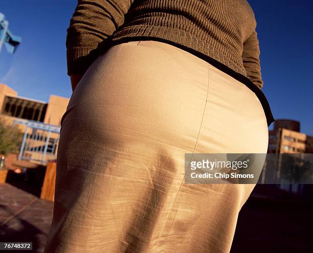 woman's buttocks in tight fitting skirt - big bottom woman stock-fotos und bilder