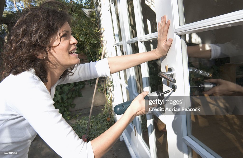 Woman installing lock on door