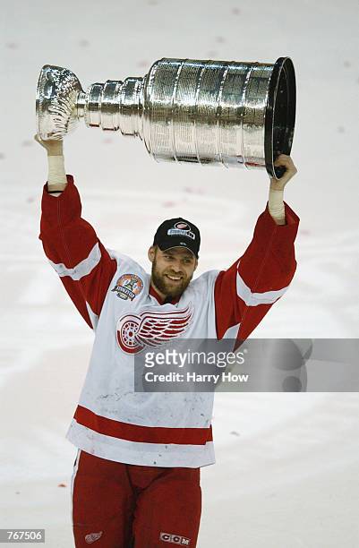 Tomas Holmstrom of the Detroit Red Wings raises the Stanley Cup after defeating the Carolina Hurricanes in game five of the NHL Stanley Cup Finals on...