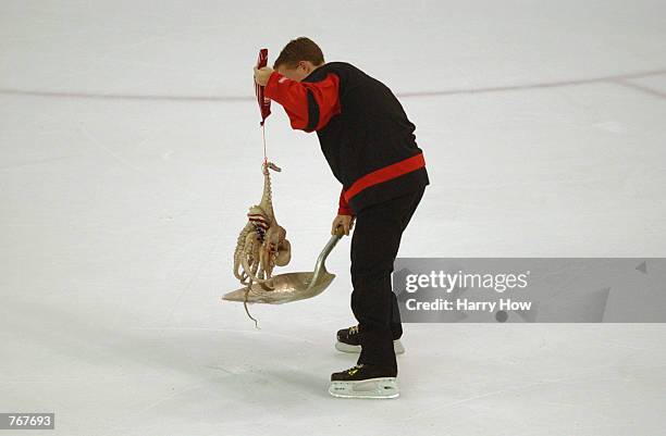 Worker cleans up an octopus that was thrown on the ice by a Detroit Red Wing's fan during game five of the NHL Stanley Cup Finals against the...