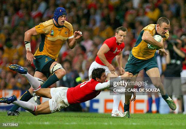 Australia's fullback Chris Latham avoids the tackle from Wales's fly-half James Hook during the rugby union World Cup group B match Wales vs....