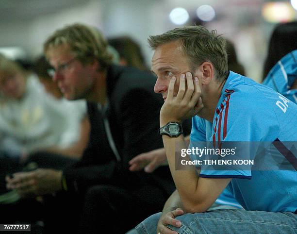 Denmark's head coach Kenneth Heiner-Moller and new coach Nielsen Per wait for their flight to Hangzhou at the Wuhan International Airport in Wuhan,...