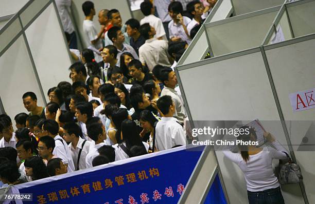 Job hunter fills in a job application form at an employment fair for graduates on September 16, 2007 in Chongqing Municipality, China. About 4.95...