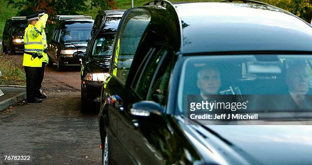 Four coffins from Saturday's helicopter crash near Lanark are taken away from the scene in hearses September 16, 2007 in Lanark, Scotland. The former...