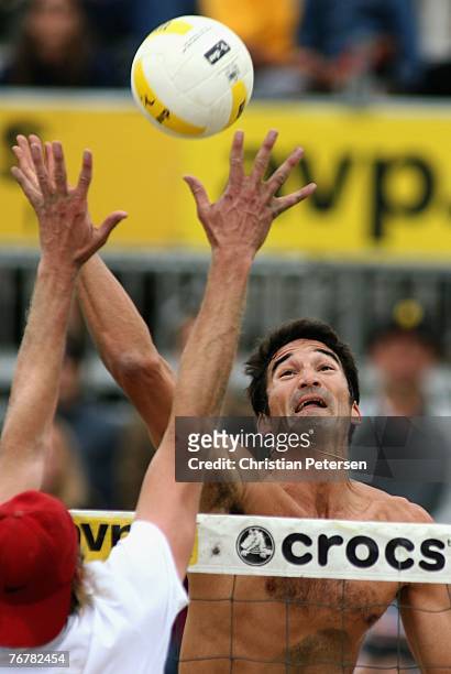 Mike Lambert hits the ball against the block of Brad Keenan in the AVP San Francisco Best of the Beach Open exhibition match at Pier 30/32 on...