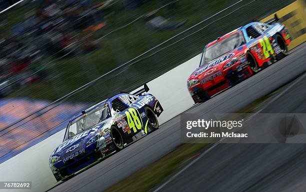 Jimmie Johnson, driver of the Lowe's Chevrolet, leads Jeff Gordon, driver of the Dupont Chevrolet, during the NASCAR Nextel Cup Series Sylvania 300...