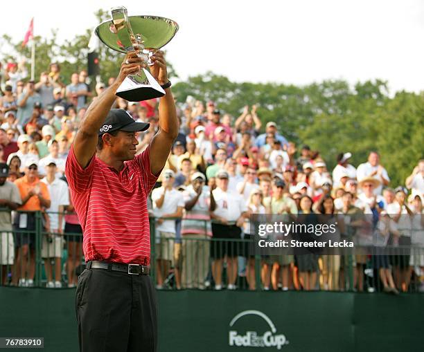 Tiger Woods holds the FedEx Cup trophy after winning the TOUR Championship, the final event of the new PGA TOUR Playoffs for the FedExCup at East...