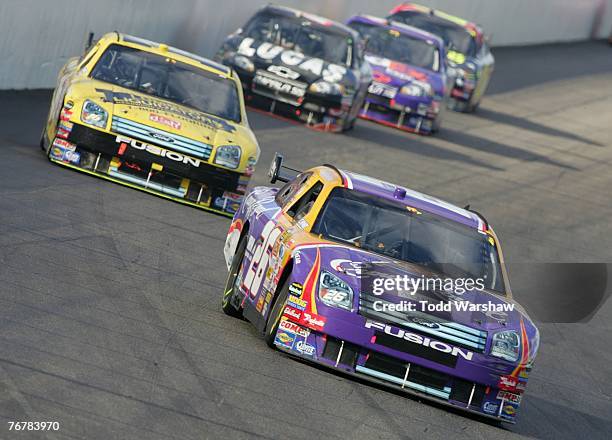 Jamie McMurray, driver of the Crown Royal Ford, leads a line of cars during the NASCAR Nextel Cup Series Sylvania 300 at New Hampshire International...