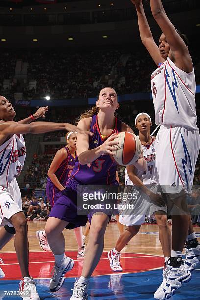 Penny Taylor of the Phoenix Mercury drives to the basket against Kara Braxton and Swin Cash of the Detroit Shock during Game Five of the WNBA Finals...