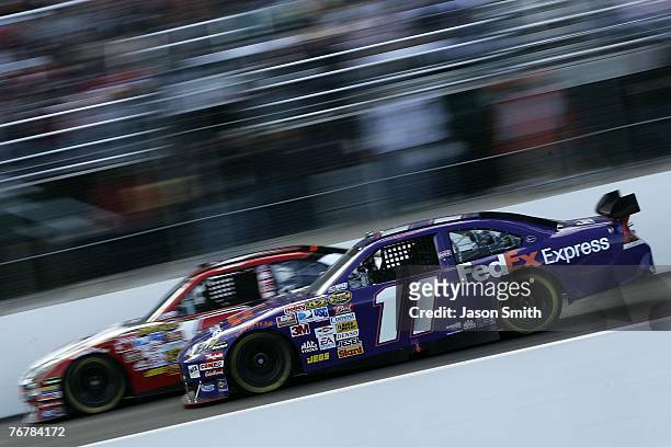 Denny Hamlin, driver of the FedEx Express Chevrolet, races Robby Gordon, driver of the Jim Beam Black Chevrolet, during the NASCAR Nextel Cup Series...
