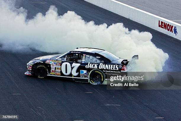 Clint Bowyer, driver of the Jack Daniel's Chevrolet, does a burnout after winning the NASCAR Nextel Cup Series Sylvania 300 at New Hampshire...
