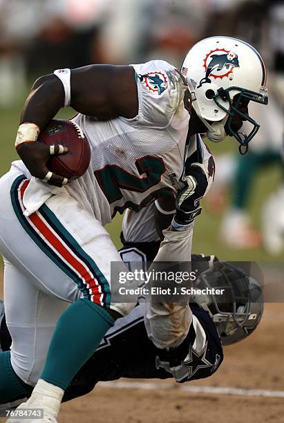 Running back Jesse Chatman of the Miami Dolphins is pulled down by Safety Roy Williams of the Dallas Cowboys in the fsecond half at Miami Dolphin...