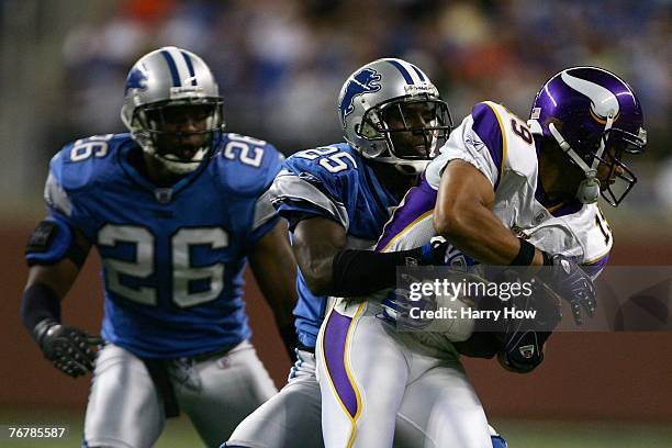 Bobby Wade of the Minnesota Vikings tries to break free from Fernando Bryant and Kenoy Kennedy of the Detroit Lions during the fourth quarter at Ford...