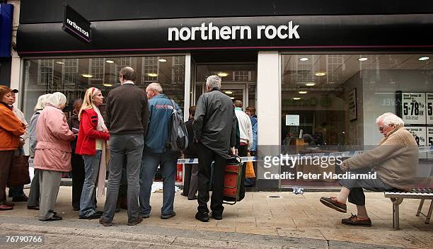 Customers wait in line to remove their savings from a branch of The Northern Rock bank on September 17, 2007 in Kingston-Upon-Thames, England....